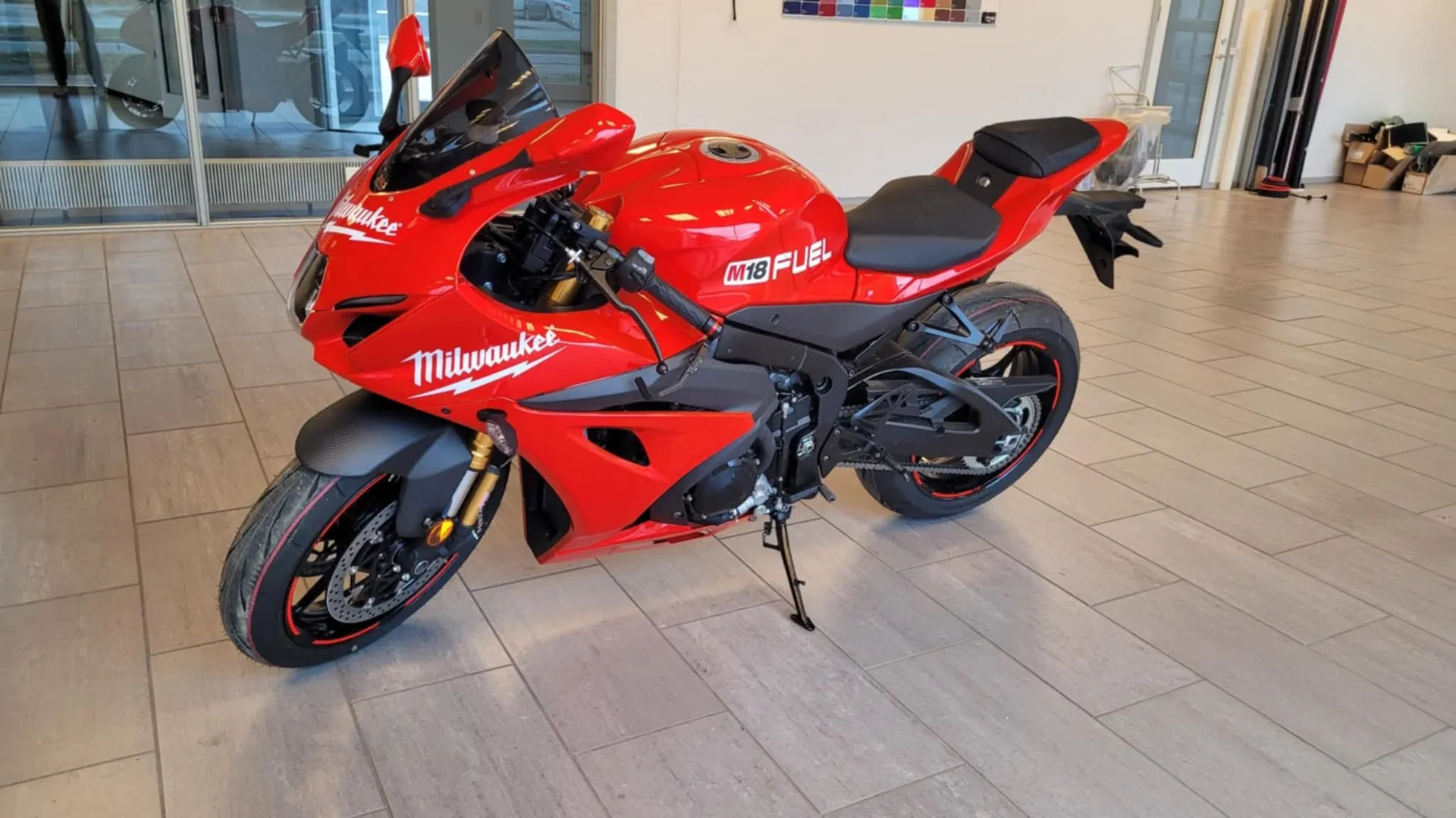 Rød sportsmotorcykel folieret med sponsorgrafik
